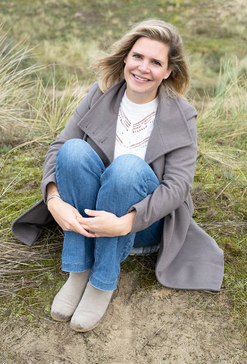 Danielle zittend in het duingras